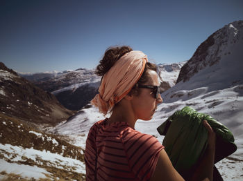 Rear view of woman on snowcapped mountain against sky