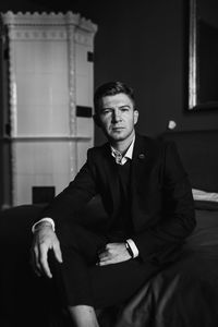 Portrait of young man standing against wall