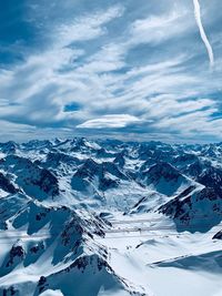 Aerial view of snowcapped mountains against sky