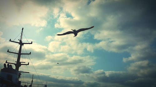 Low angle view of silhouette birds flying against sky