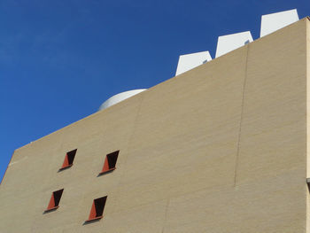 Low angle view of building against clear blue sky