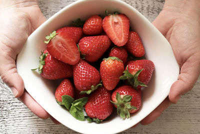 Midsection of person holding strawberries