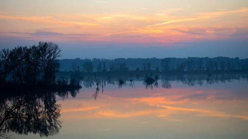 Scenic view of lake against romantic sky at sunset