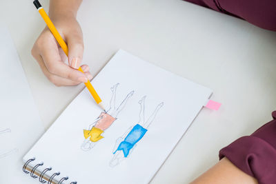 High angle view of woman drawing on paper