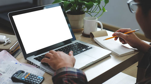 Midsection of businessman working on laptop