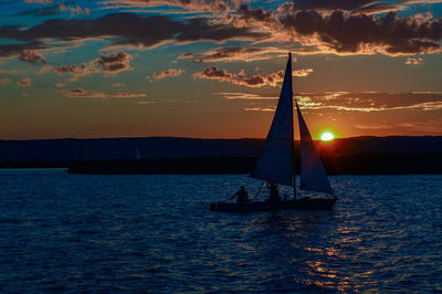 Silhouette of boat in sea at sunset