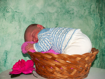 Baby girl sleeping in wicker basket at home