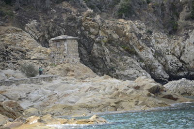 Rock formations by sea against mountain