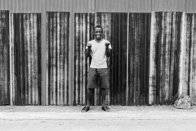 Portrait of young man standing against wall