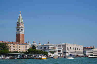 Buildings in city against clear blue sky