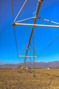 Windmill on field against clear blue sky