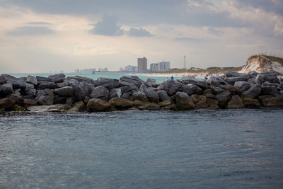Rocks by sea against sky