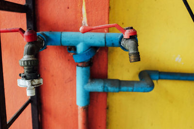 Close-up of metal pipe against yellow wall