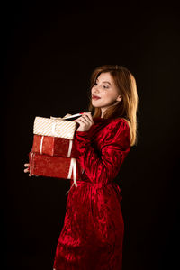 Portrait of a smiling young woman against black background