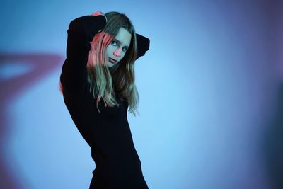 Portrait of woman standing against blue sky