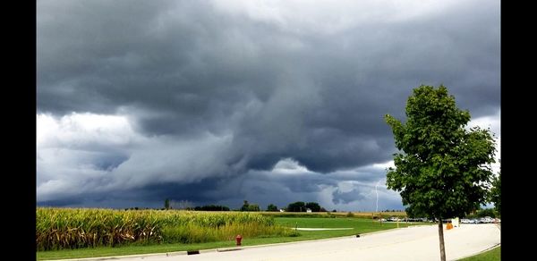 Scenic view of field against cloudy sky