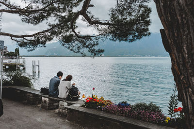 Rear view of two people overlooking calm sea