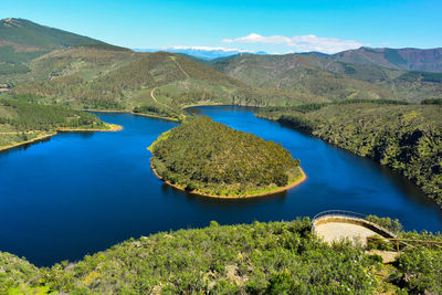 Scenic view of lake and mountains against blue sky