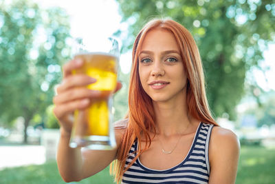 Portrait of smiling young woman drinking glass