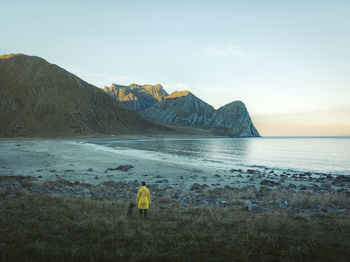 Rear view of man on beach against sky