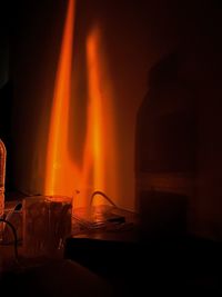 Rear view of man standing by campfire at night