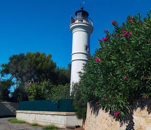 Low angle view of lighthouse against sky and trees