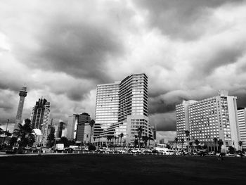 View of cityscape against cloudy sky