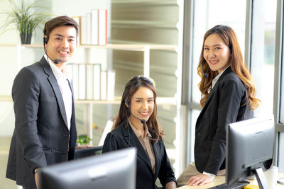 Young woman using laptop phone in office