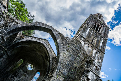 Low angle view of old ruin church against cloudy sky