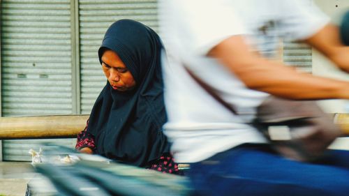 Man sitting in front of woman