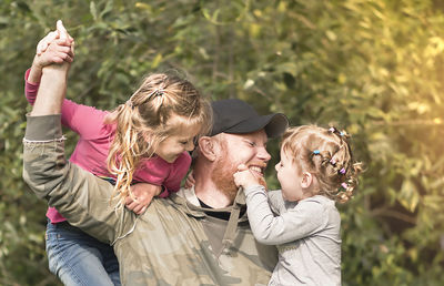 Smiling man with daughters