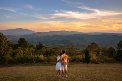 Rear view of women against mountains during sunset