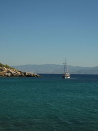 Sailboat sailing in sea against clear sky