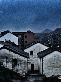 Houses against cloudy sky