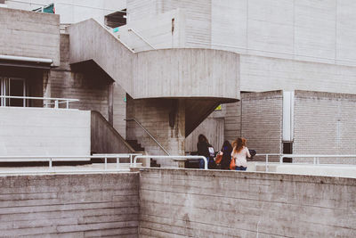 Rear view of people walking on bridge