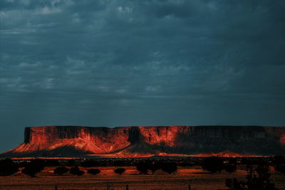 View of bonfire on landscape against cloudy sky