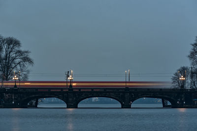 Bridge over river in city at night