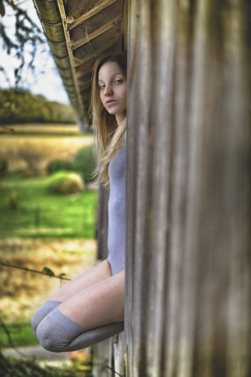 one person, young adult, real people, casual clothing, young women, leisure activity, women, lifestyles, day, hair, looking at camera, three quarter length, long hair, beauty, beautiful woman, selective focus, plant, hairstyle, outdoors, teenager, contemplation