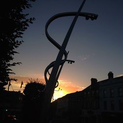 Low angle view of silhouette buildings against sky at sunset