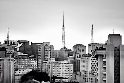 Buildings in city against clear sky