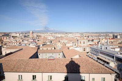 Buildings in city against clear blue sky