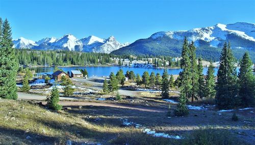 Scenic view of lake and mountains against clear blue sky