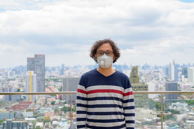 Portrait of man standing against cityscape