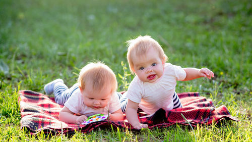 Portrait of cute siblings on grass