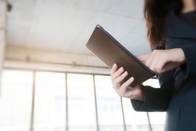 Midsection of woman using smart phone