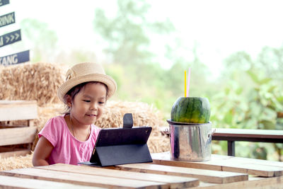 Cute girl using mobile phone on table