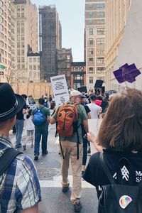 Rear view of people on street against buildings in city