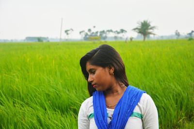 Young woman looking away on field
