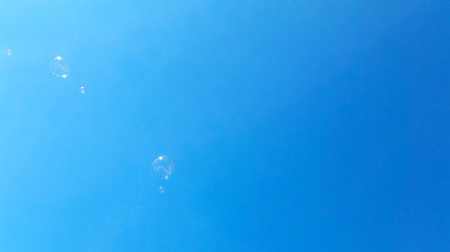 Low angle view of moon against blue sky