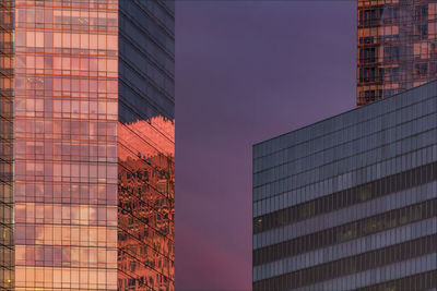 Low angle view of office buildings against sky during sunset